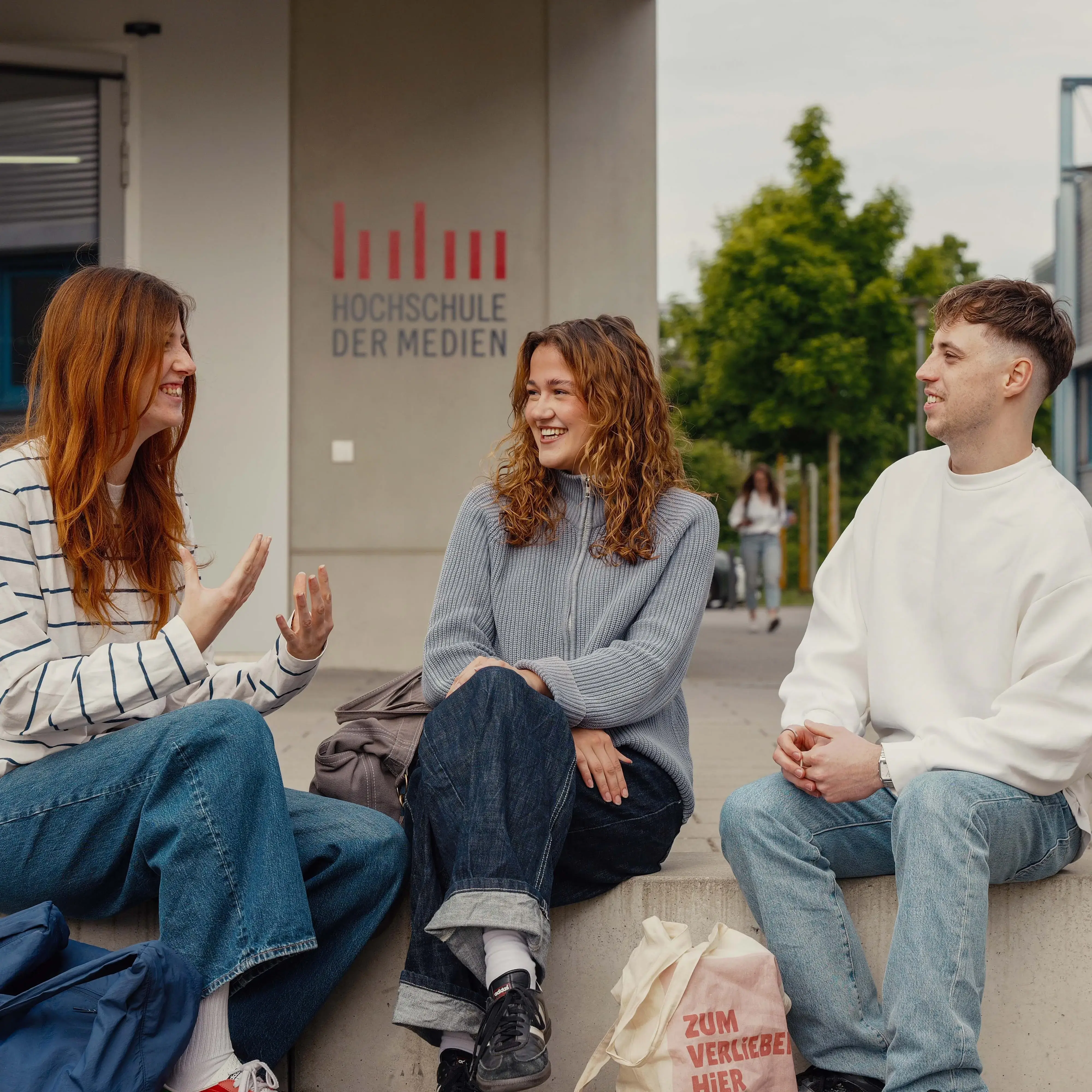 Studierende unterhalten sich vor der Hochschule der Medien.