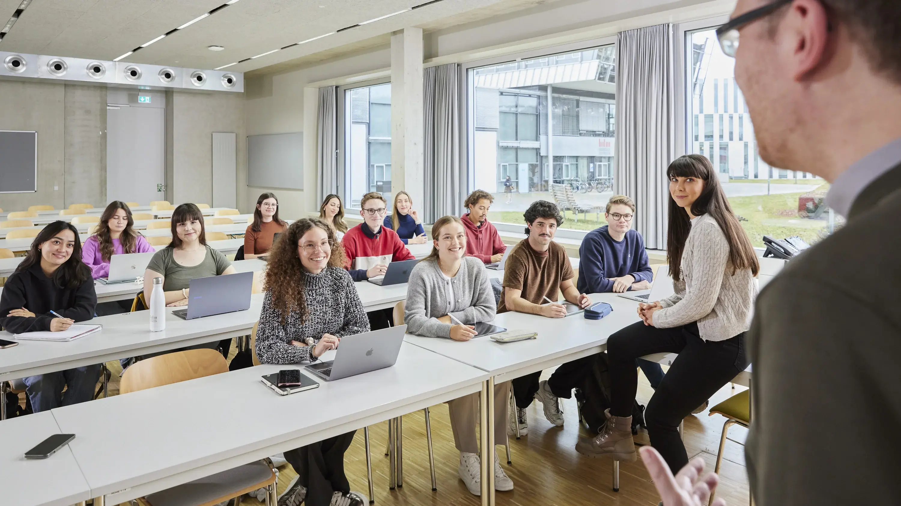 Ein Professor mit seinen Studierenden in der Vorlesung.