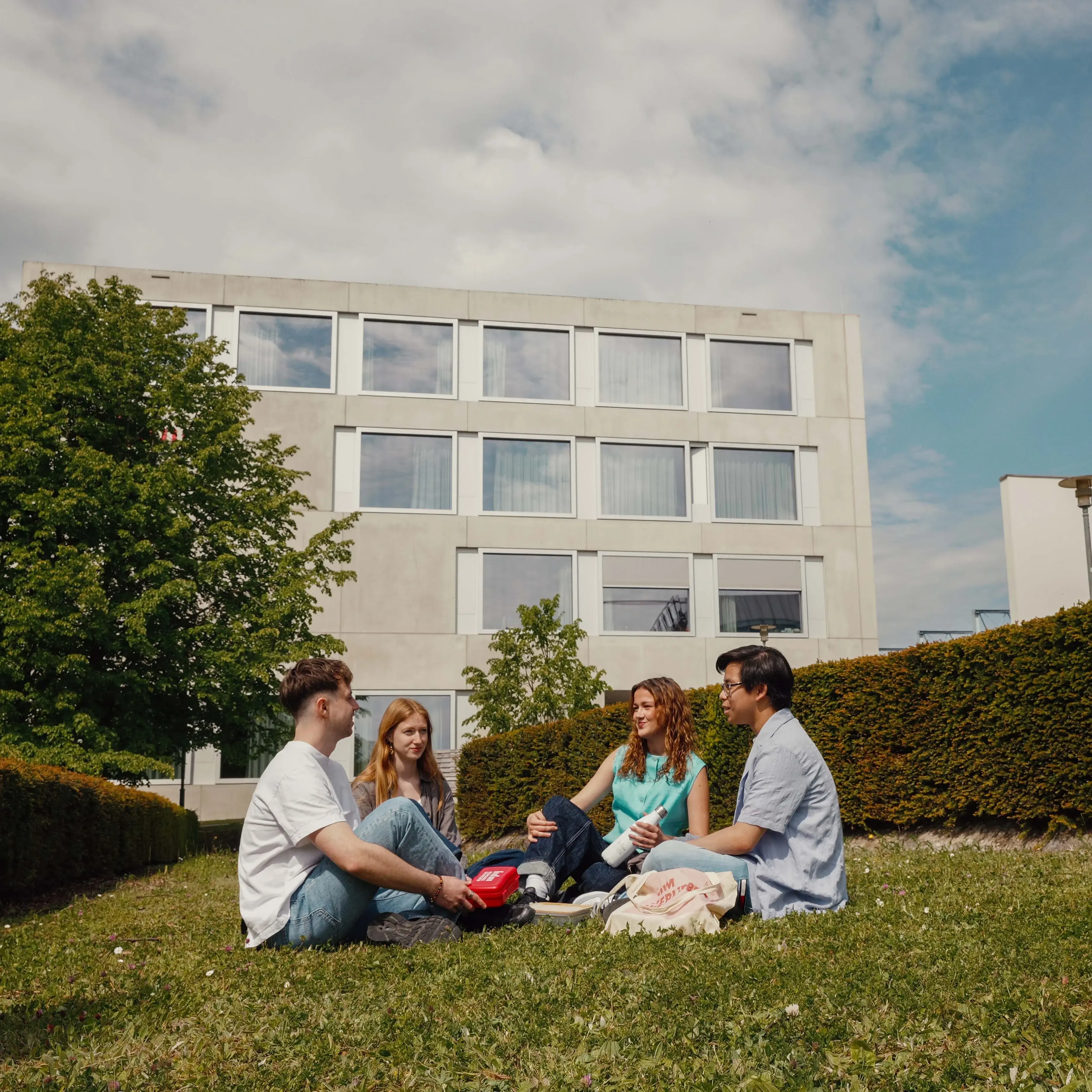 Students picnicking on the campus of the Hochschule der Medien.