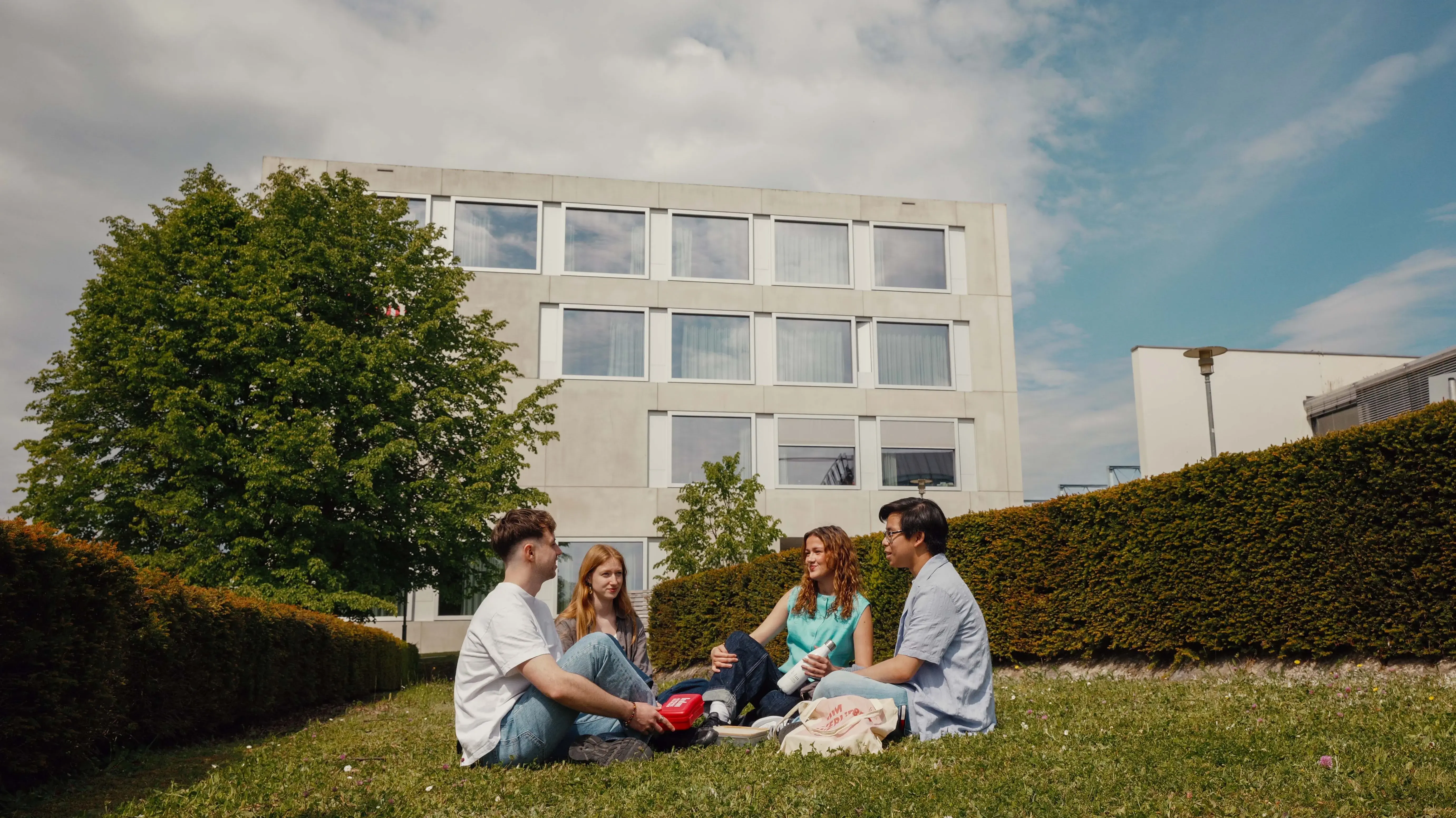Students picnicking on the campus of the Hochschule der Medien.