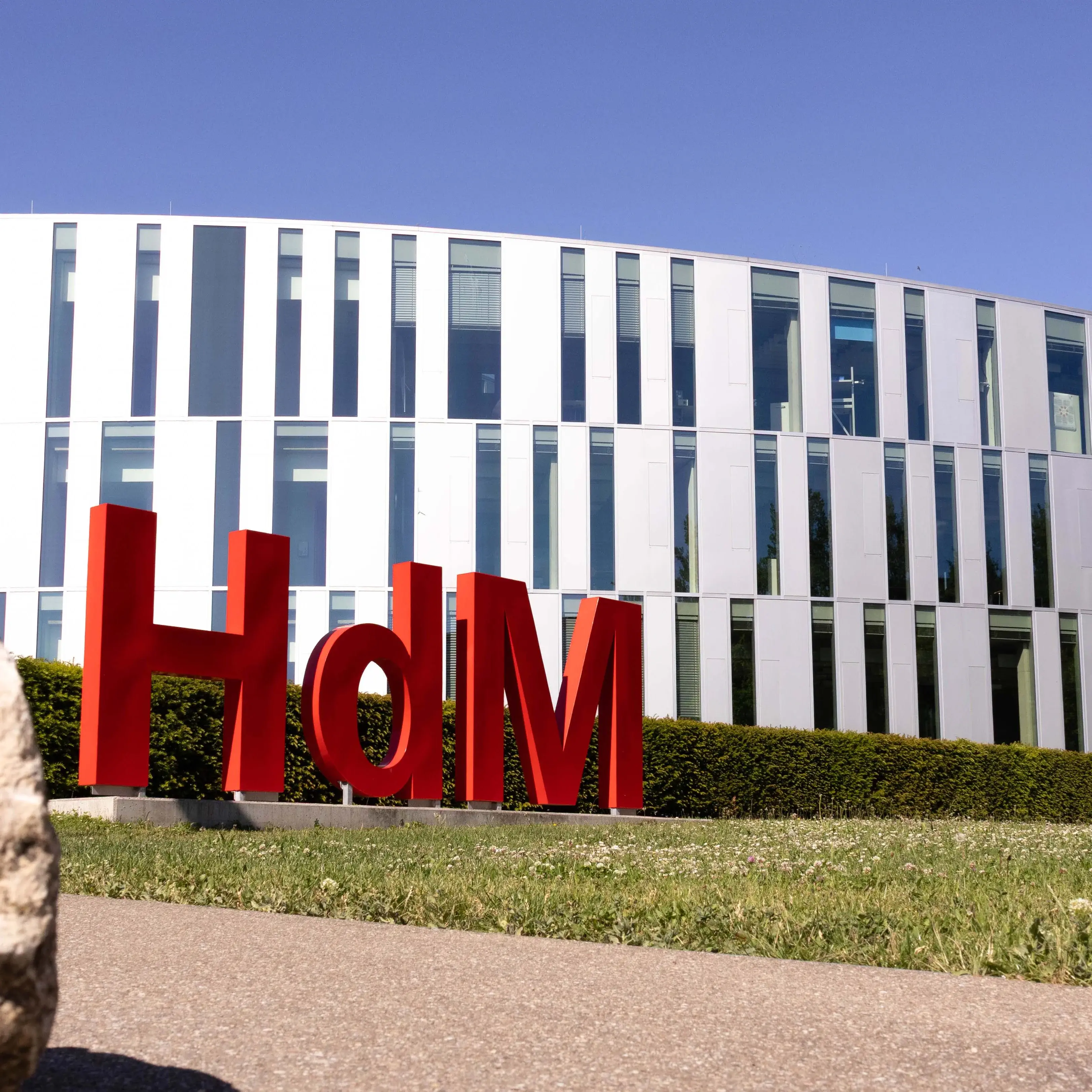 Eine Hollywood-Schriftzeichen-Imitation mit den Buchstaben H,d und M, ziert den Campus der Hochschule der Medien vor dem sogenannten Zitronenschnitz-Gebäude.